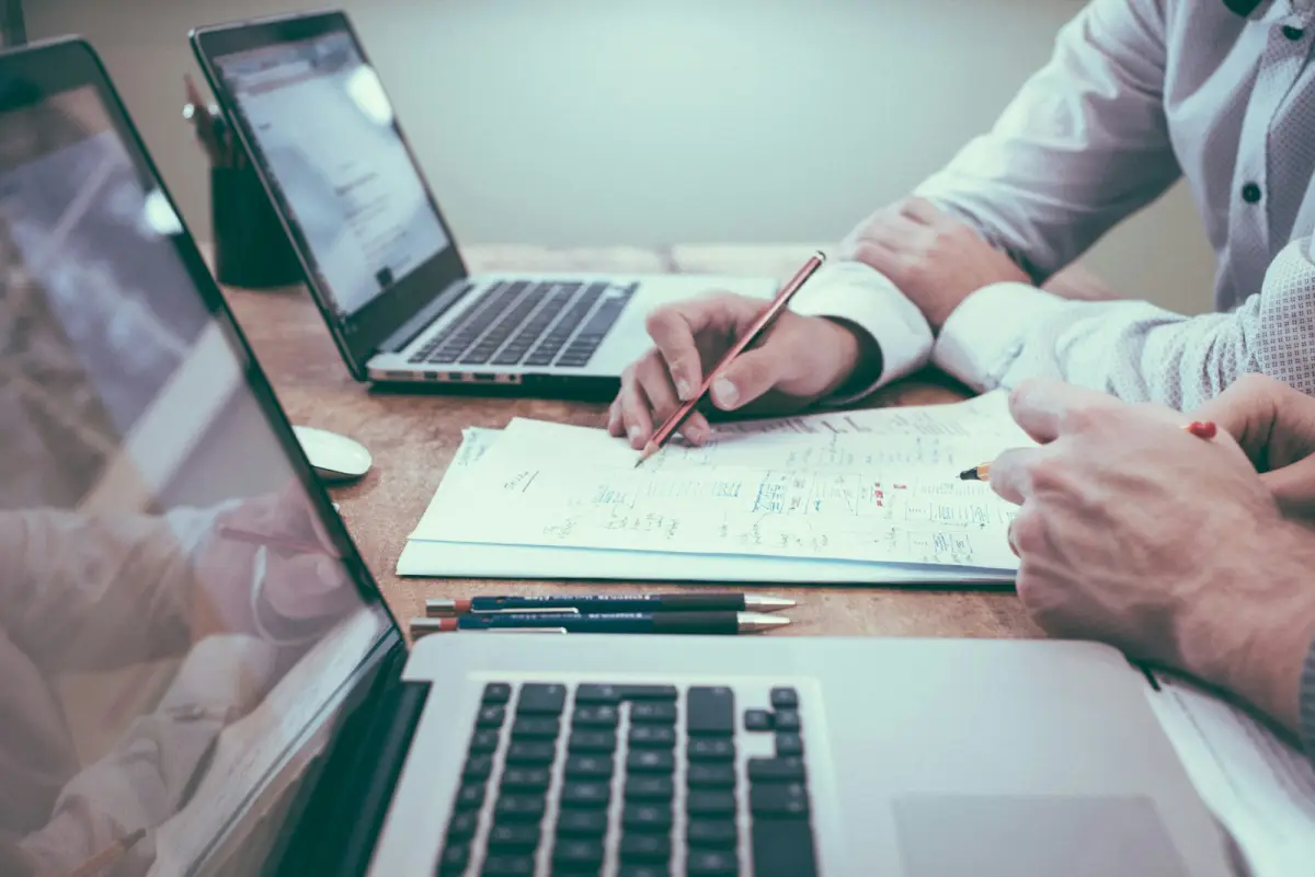 Dos profesionales revisando contratos y documentación de empresa